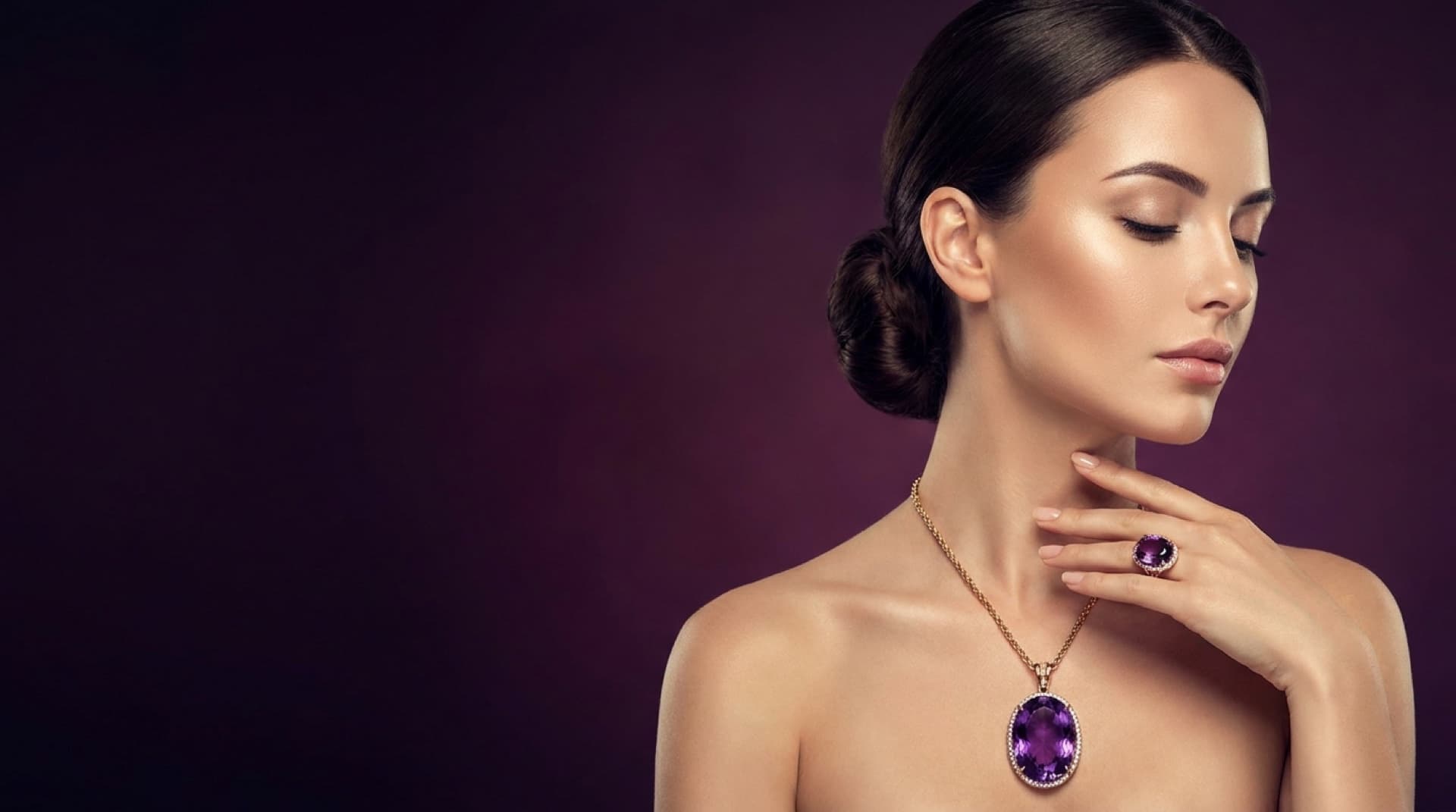 Woman wearing an amethyst pendant and gemstone ring